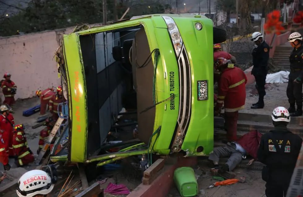 Handout picture released by Andina of firefighters surrounding a tourist bus after it went out of the track in Lima on July 10, 2017. \nAt least seven people were killed Sunday after a tourist bus got out of the track as it went down a hill in Rimac district, firefighters informed. / AFP PHOTO / ANDINA AND AFP PHOTO / HO / RESTRICTED TO EDITORIAL USE - MANDATORY CREDIT \