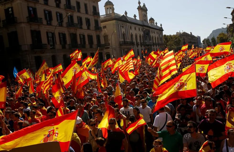 People wave Spanish and Catalan flags during a march in downtown Barcelona, Spain, to protest the Catalan government's push for secession from the rest of Spain, Sunday Oct. 8, 2017. Sunday's rally comes a week after separatist leaders of the Catalan government held a referendum on secession that Spain's top court had suspended and the Spanish government said was illegal. (AP Photo/Francisco Seco)