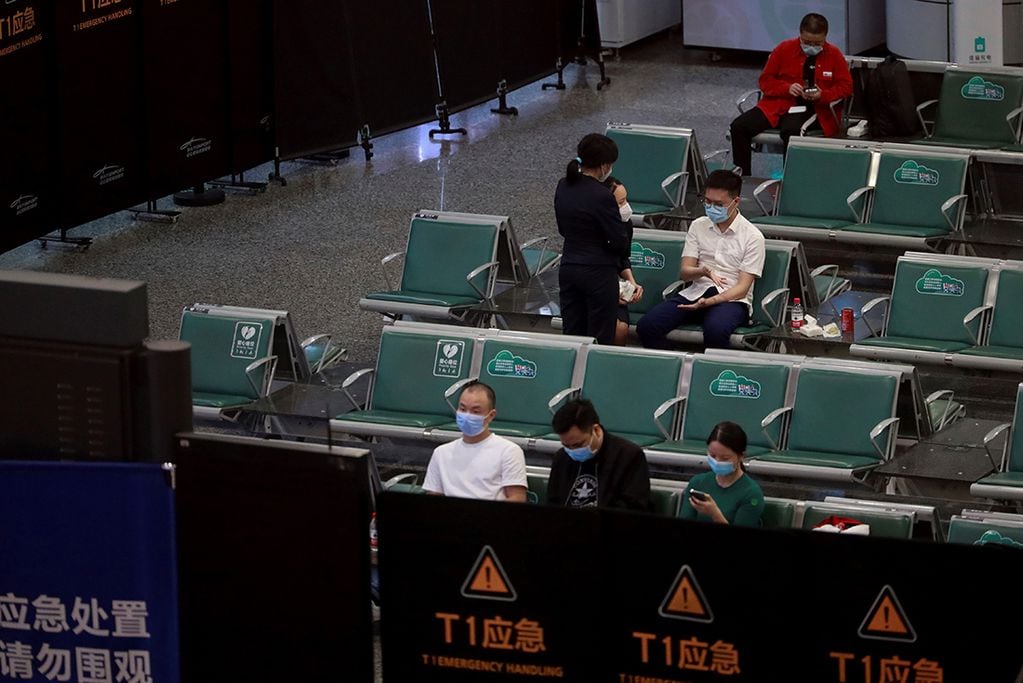 Las personas se sientan en un área temporalmente acordonada para los familiares de las víctimas a bordo del vuelo MU5735 de China Eastern, en el Aeropuerto Internacional Guangzhou Baiyun en Guangzhou, en el sur de China. (AP)