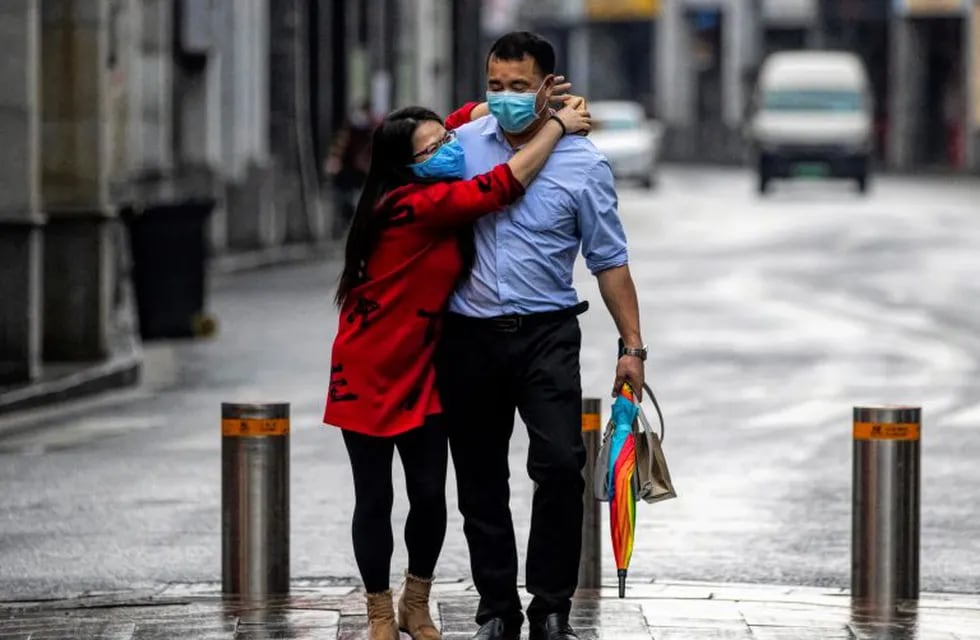 Guangzhou (China), 14/02/2020.- A couple wearing protective masks walks on the street on Valentine's Day in Guangzhou, China, 14 February 2020. Many flower markets, restaurants, cinemas and others stores remained closed due to the coronavirus crisis. The outbreak, which originated in the Chinese city of Wuhan, has so far killed at least 1,383 people with over 64,000 infected worldwide, mostly in China. (Cine) EFE/EPA/ALEX PLAVEVSKI