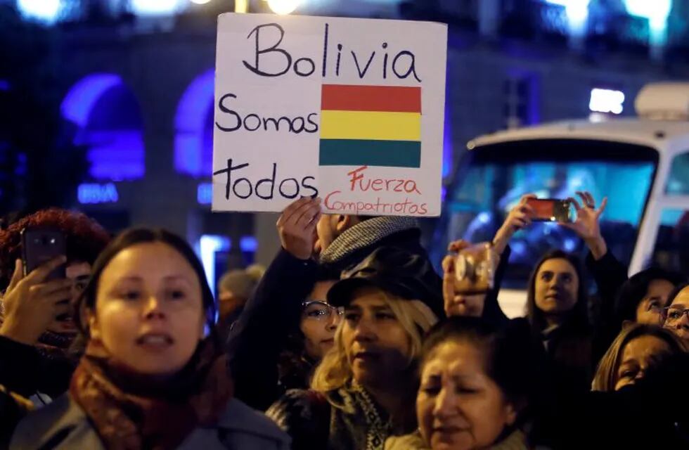 Varias personas se concentran mientras ondean banderas de Bolivia, este lunes, en la Puerta del Sol de Madrid, con motivo de la renuncia de Evo Morales a la Presidencia forzado por los militares. Crédito: EFE/JuanJo Martín.