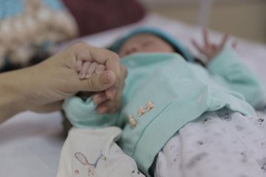 Neison toma la mano de su mamá Paula en el Hospital Materno Neonatal de Posadas. Su nacimiento inauguró la sala de partos del flamante centro de salud. (Foto Canal 12)