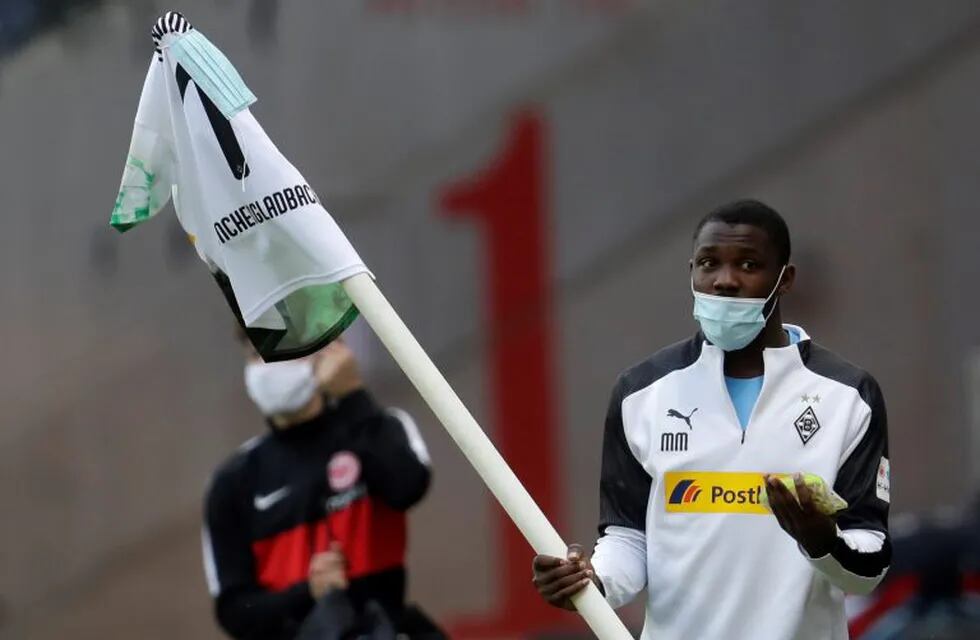 Moenchengladbach's Marcus Thuram carries the corner flag after the German Bundesliga soccer match between Eintracht Frankfurt and Borussia Moenchengladbach in Frankfurt, Germany, Saturday, March 16, 2020. The German Bundesliga becomes the world's first major soccer league to resume after a two-month suspension because of the coronavirus pandemic. (AP Photo/Michael Probst, Pool)