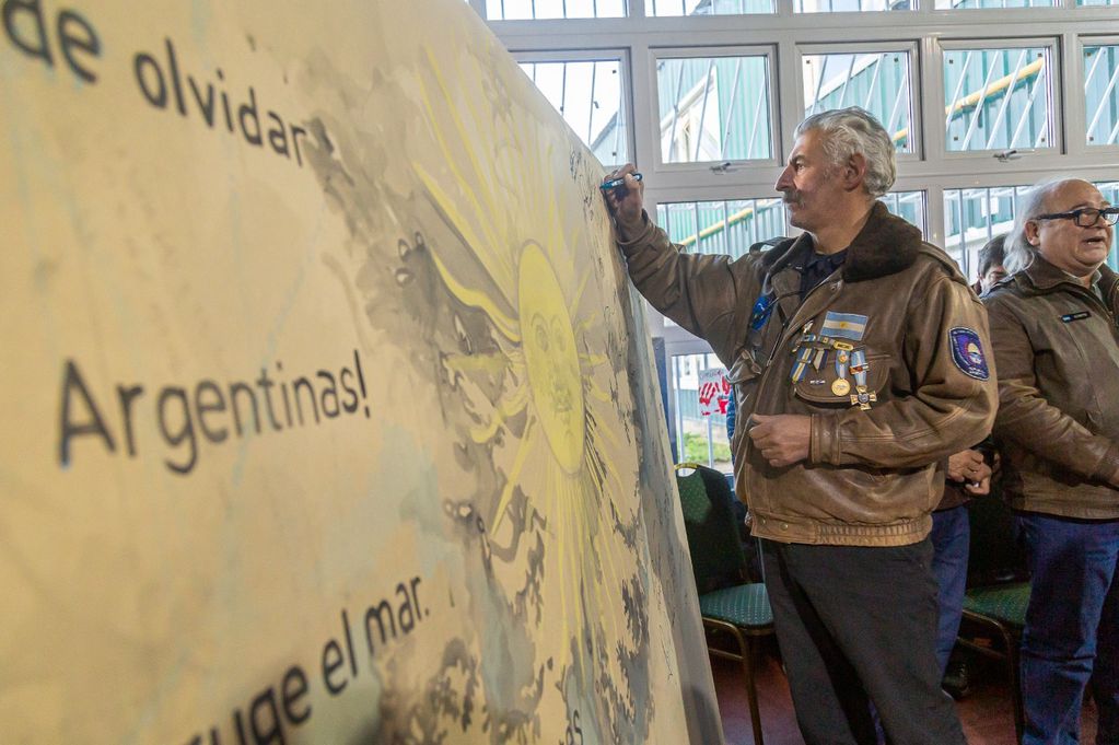 VGM Parodi, firmando el mural "Malvinas nos une", acompañó el VGM Hugo Frette y VGM presentes.