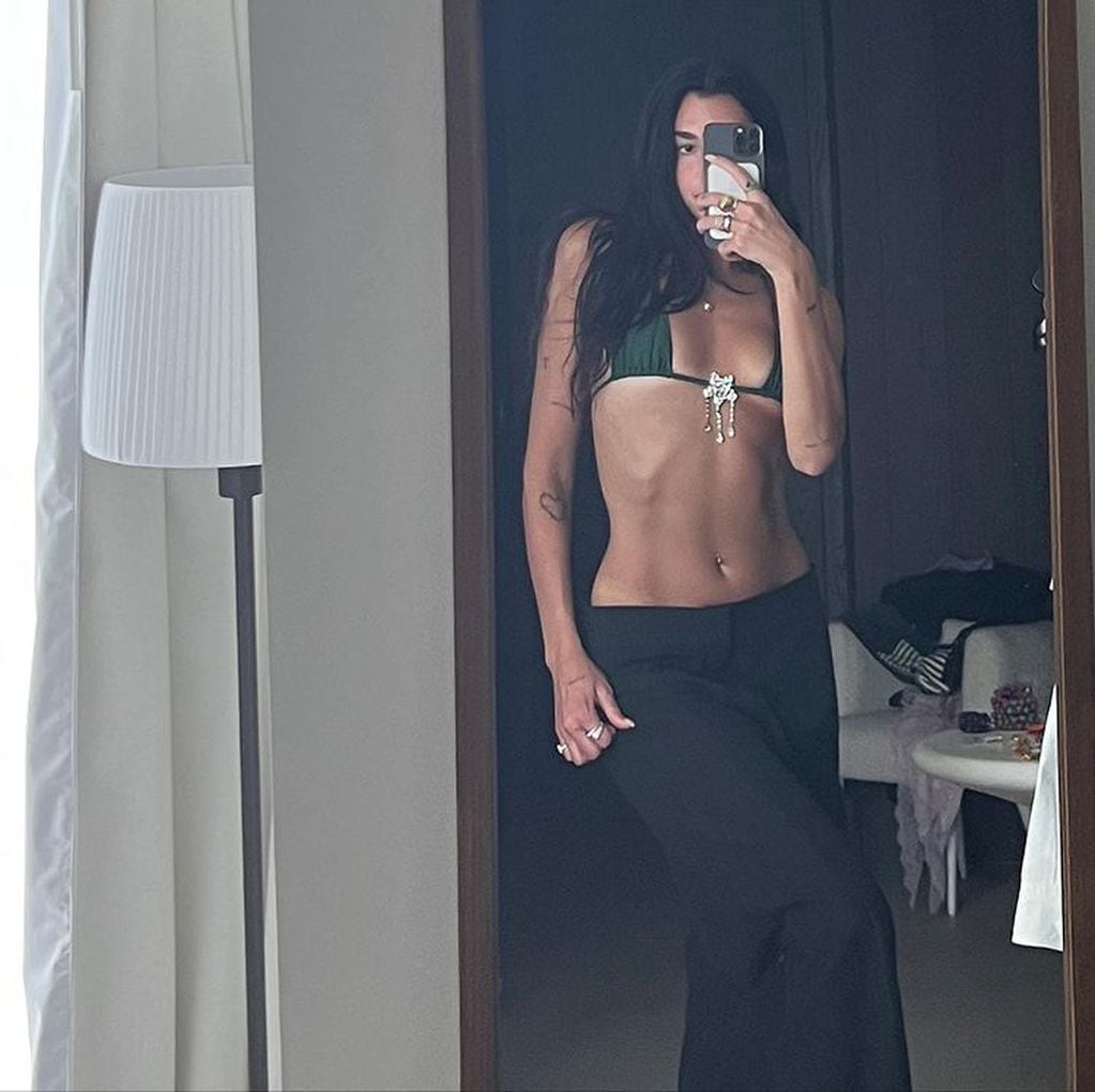 Dua Lipa compartió una foto en su cuenta de Instagram luciendo una bikini y un pantalón de gabardina.
