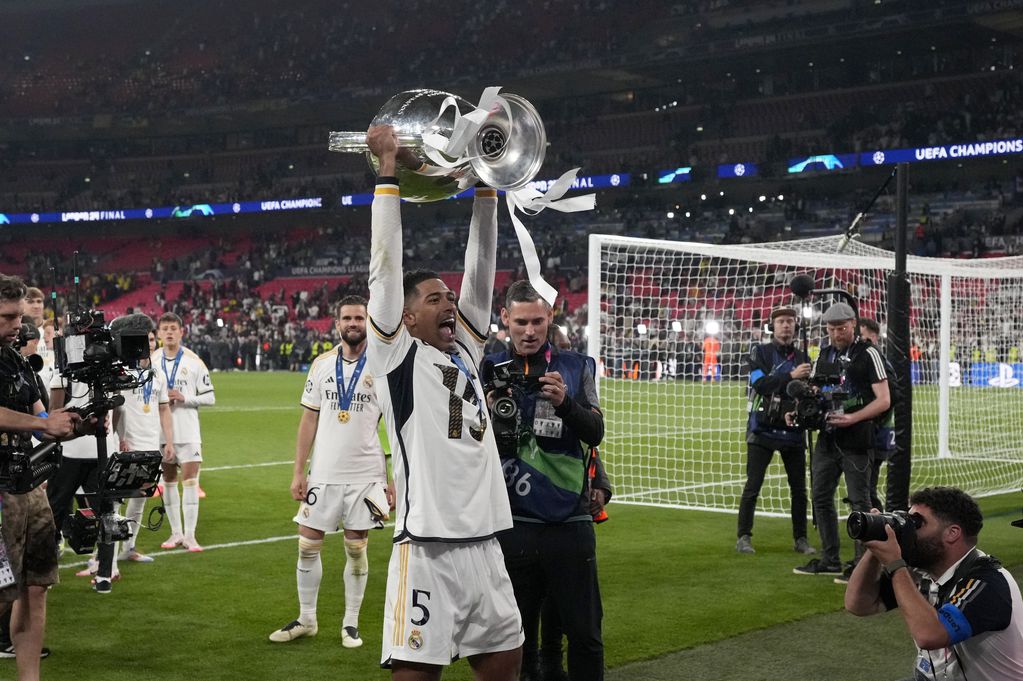 Jude Bellingham del real Madrid celebra con el trofeo después de que su equipo ganó la final de la Liga de Campeones al superar al Borussia Dortmund en Londres el sábado 1 de junio del 2024. (AP Foto/Frank Augstein)