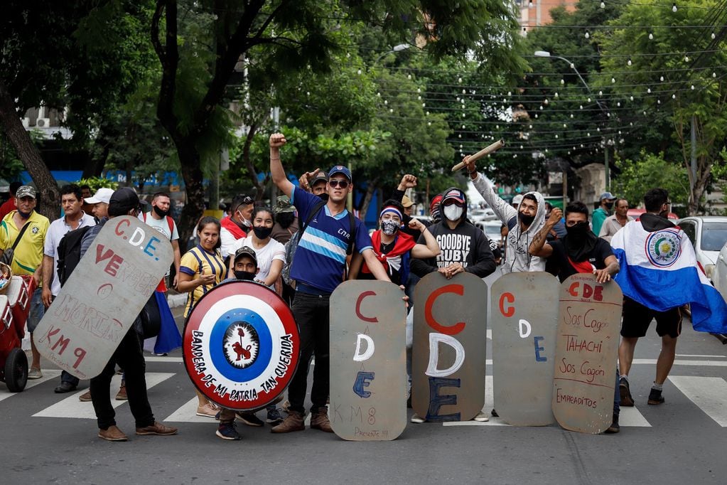 Manifestantes con escudos improvisados protestan durante una marcha para exigir la renuncia del presidente de Paraguay, Mario Abdo Benítez