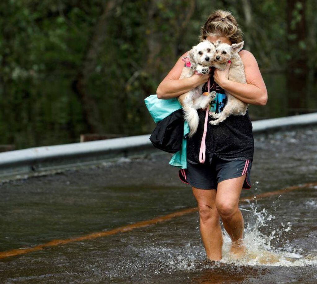 Lisa Shackleford abraza a sus perros Izzy y Bella mientras huye del desborde de un río. Crédito: REUTERS/Jonathan Drake.