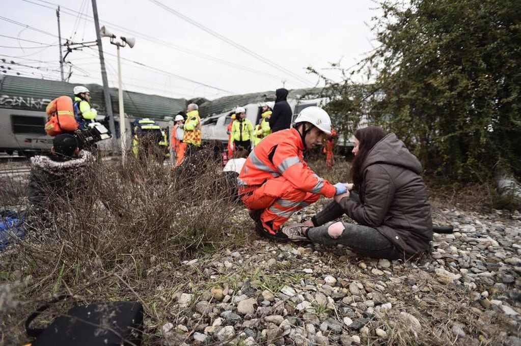 Un miembro de los servicios de emergencia asiste a una pasajera después de que un tren descarrilara cerca de Milán