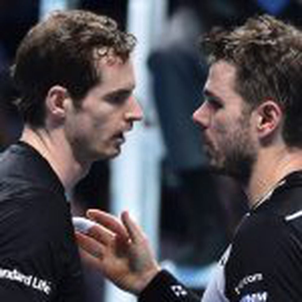 Britain's Andy Murray (L) shakes hands with Switzerland's Stan Wawrinka (R) at the net after Murray won their round robin stage men's singles match on day six of the ATP World Tour Finals tennis tournament in London on November 18, 2016. / AFP PHOTO / Glyn KIRK