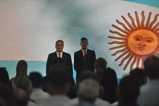 El intendente Martín Llaryora y el viceintendente Daniel Passerini -y candidato a la intendencia- miran de pie la pantalla que emitió el video con los logros de gestión.