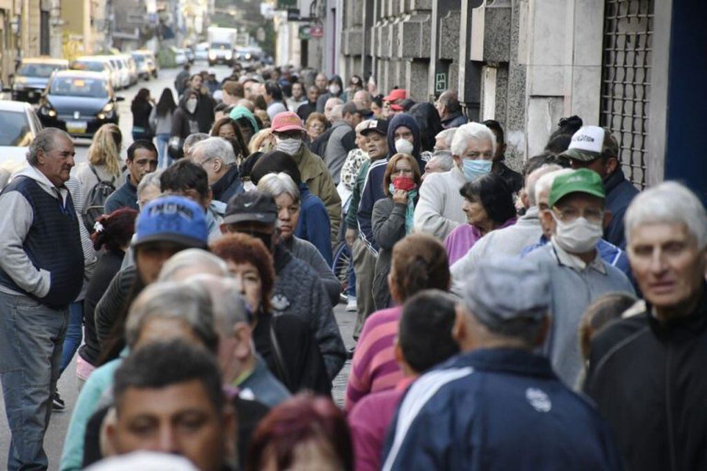 Extensas filas en los bancos porteños y del Conurbano para cobrar jubilaciones y planes sociales. (Clarín)