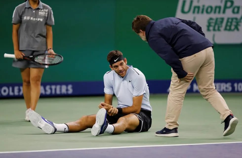 Juan Martin del Potro of Argentina holds his hand chats with the umpire after he fell during his men's singles quarterfinals match against Viktor Troicki of Serbia in the Shanghai Masters tennis tournament at Qizhong Forest Sports City Tennis Center in Shanghai, China, Friday, Oct. 13, 2017. (AP Photo/Andy Wong)