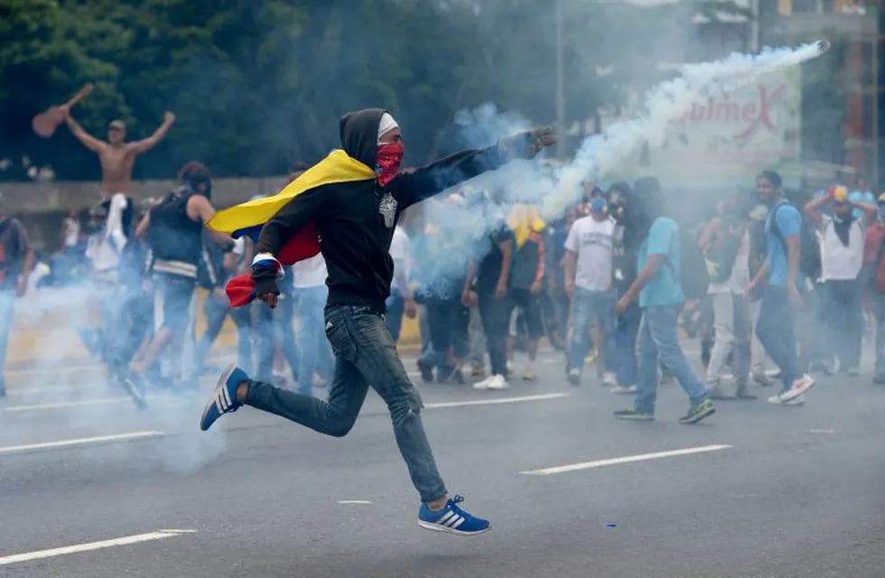 TOPSHOT - Demonstrators clash with the riot police during a protest against Venezuelan President Nicolas Maduro, in Caracas on April 20, 2017.nVenezuelan riot police fired tear gas Thursday at groups of protesters seeking to oust President Nicolas Maduro,