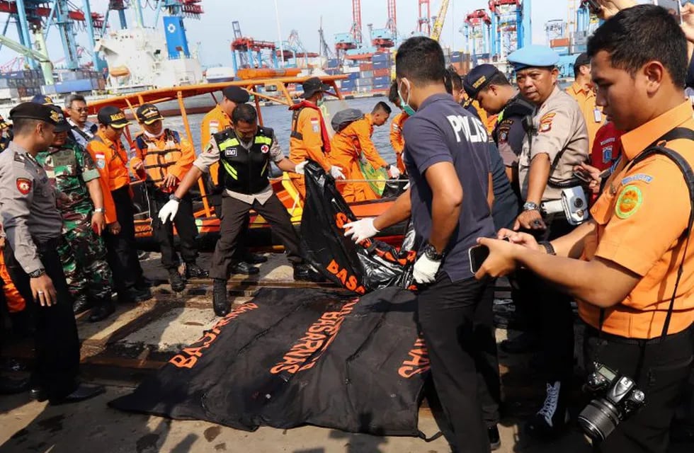 Members of a rescue team line up body bags at the port in Tanjung Priok, North Jakarta, on October 29, 2018, after being recovered from the sea where Lion Air flight JT 610 crashed off the north coast earlier in the day. - A brand new Indonesian Lion Air plane carrying 189 passengers and crew crashed into the sea on October 29, officials said, moments after it had asked to be allowed to return to Jakarta. (Photo by RESMI MALAU / AFP)