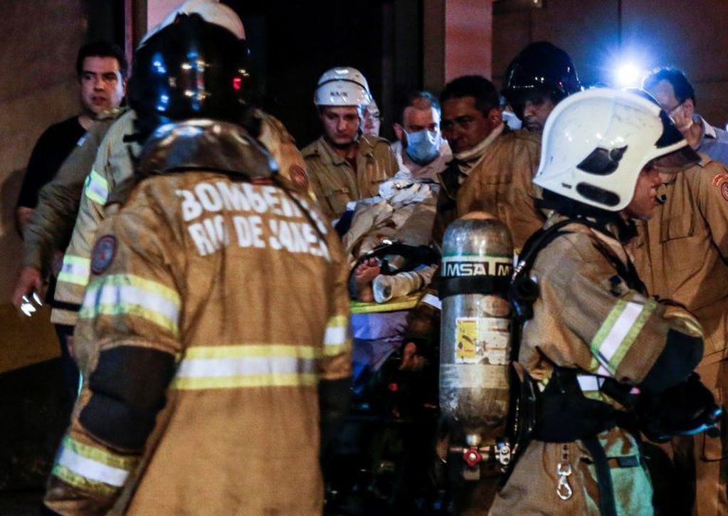 Bomberos y personal médico evacúan este jueves a un herido durante un incendio en un hospital en Río de Janeiro (Brasil). Crédito: EFE/Antonio Lacerda.