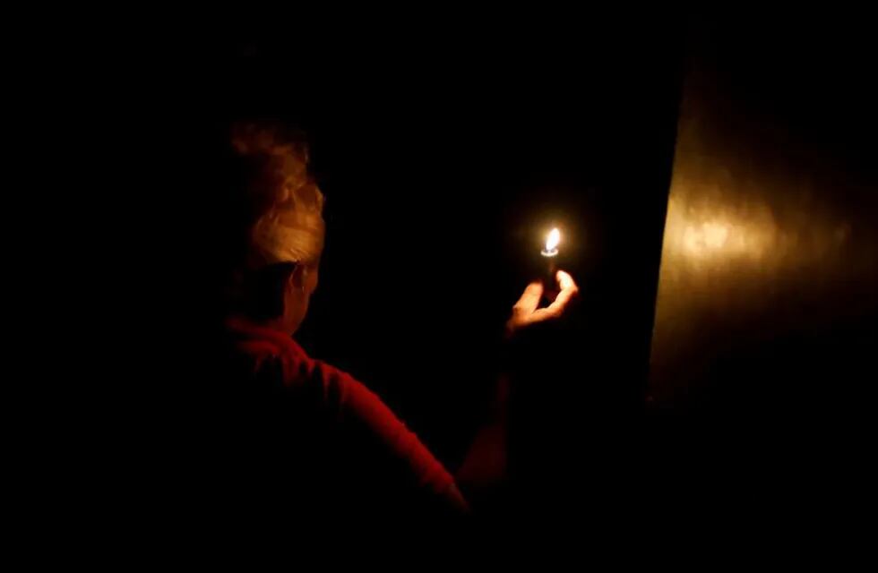 cortes de luz apagones \r\n\r\nA woman uses a candle as she enters her house during the second day of a blackout in Caracas, Venezuela March 9, 2019. REUTERS/Carlos Jasso venezuela Caracas  gigantesco apagon en venezuela corte de luz masivo crisis energetica