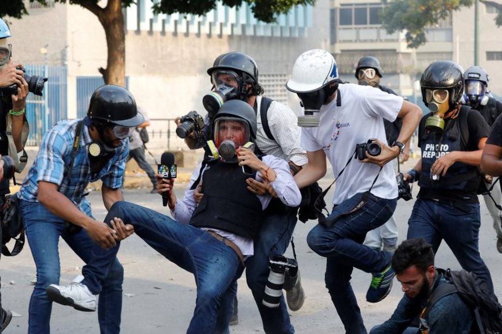 Periodistas ayudan al reportero Gregory Jaimes, impactado por una bala de goma en la cara (Foto: AP/Ariana Cubillos).