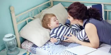 Niño enfermo en cama con su madre