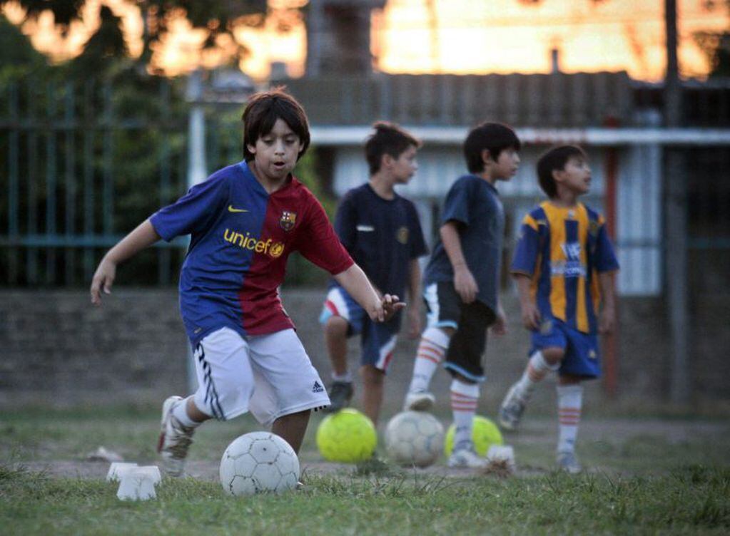 Niños juegan al fútbol en una escuelita en Rosario. (EFE)