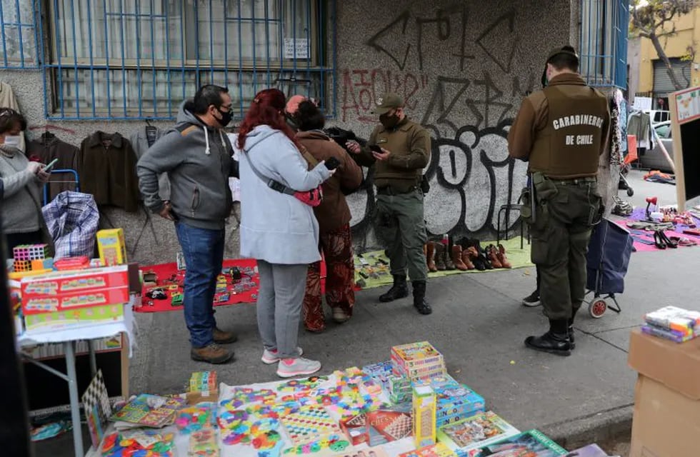 Police officers check people at an informal flea market managed mainly by unemployed people, amid the spread of the coronavirus disease (COVID-19) in Santiago, Chile May 29, 2020.  REUTERS/Ivan Alvarado