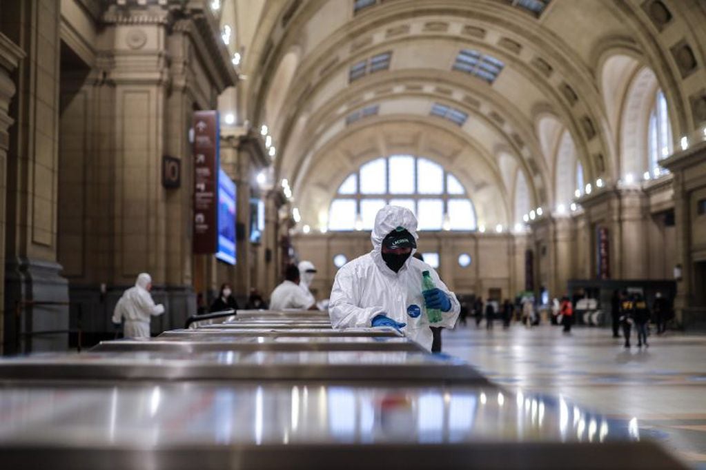 Un empleado de limpieza desinfecta la entrada a la estación ferroviaria de Constitución en la ciudad de Buenos Aires (Argentina) (Foto: EFE/Juan Ignacio Roncoroni)