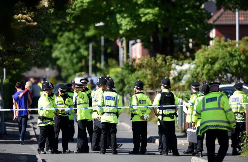 Police officers stand on duty on a cordoned-off road in Fallowfield, Manchester, in northwest England on May 23, 2017, as they search a resdiential property nearby following the May 22 deadly terror attack at the Ariana Grande concert at the Manchester Arena.nTwenty two people have been killed and dozens injured in Britain's deadliest terror attack in over a decade after a suspected suicide bomber targeted fans leaving a concert of US singer Ariana Grande in Manchester. / AFP PHOTO / Oli SCARFF