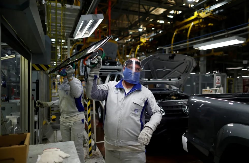 Ensambladores de Volkswagen trabajan en un modelo Amarok con equipo de protección. (Foto: REUTERS / Agustin Marcarian)