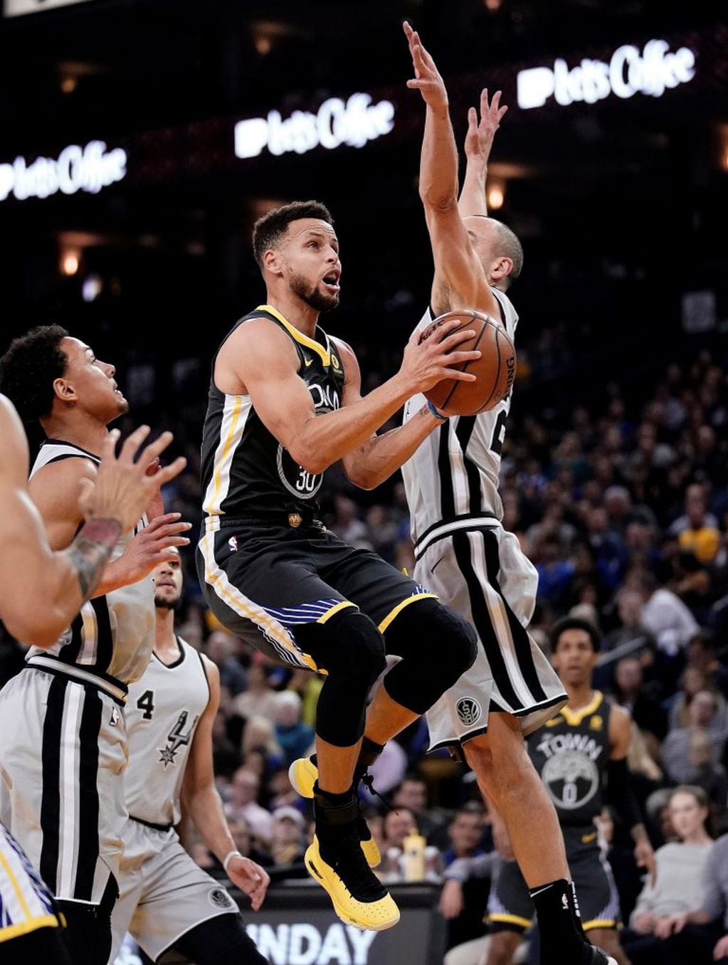 JGM02. Oakland (United States), 11/02/2018.- Golden State Warriors guard Stephen Curry (C) goes to the basket as San Antonio Spurs guard Manu Ginobili (R) defends during the first half of their NBA game at Oracle Arena in Oakland, California, USA, 10 February 2018. (Baloncesto, Estados Unidos) EFE/EPA/JOHN G. MABANGLO