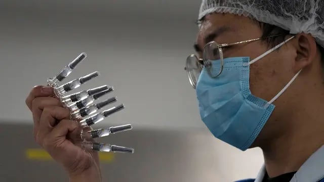 Empleado de SinoVac, en Pekín, manipula la vacuna contra el Covid-19