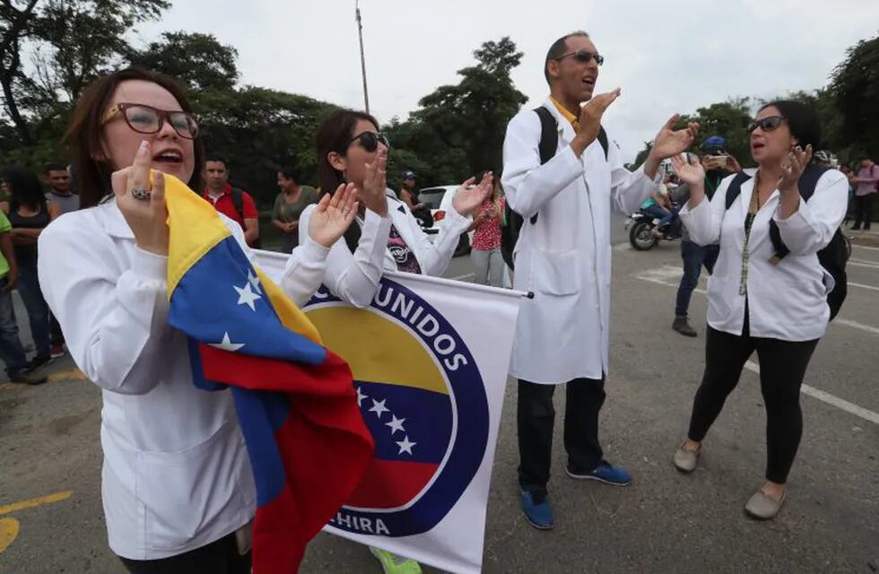CUC100. CÚCUTA (COLOMBIA), 10/02/2019.- Más de 30 médicos venezolanos participan en una manifestación este domingo en el puente Tienditas, uno de los que conecta a Venezuela con Colombia, en Cúcuta (Colombia). Los médicos se concentraron en la frontera para solicitar a las autoridades venezolanos permitir el ingreso de la ayuda humanitaria que sigue acumulándose en Cúcuta y que el Gobierno de Nicolás Maduro insiste en rechazar por considerar que se trata de un show político. EFE/ Mauricio Dueñas Castañeda Colombia cucuta  venezuela crisis politica por asuncion de presidente interino provisional protesta de medicos en el puente internacional tienditas