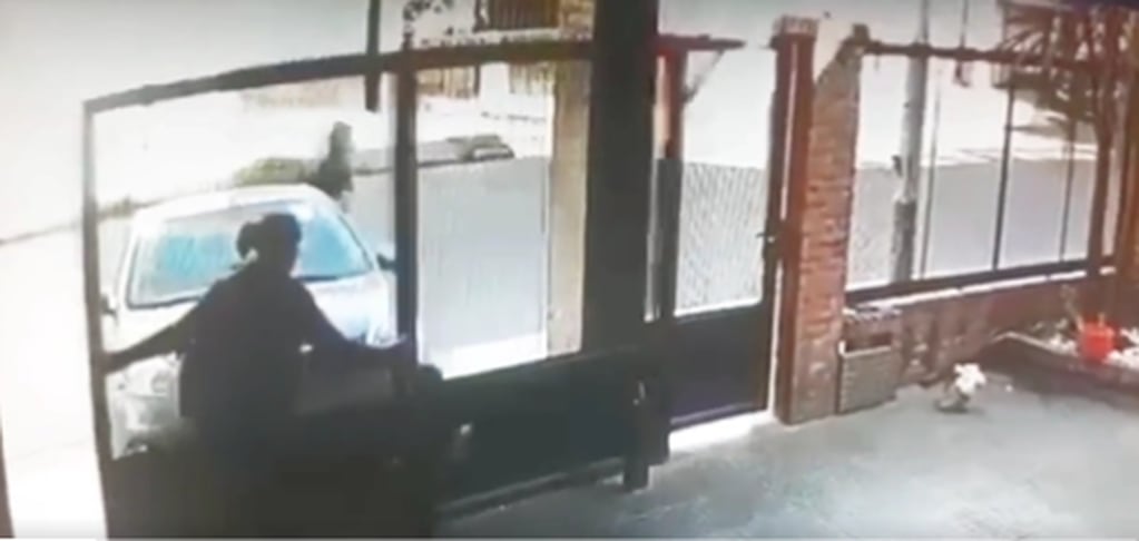 El momento previo al asalto, cuando la mujer abre el portón y enseguida se precipitan los criminales para amenazarla. Captura de video.