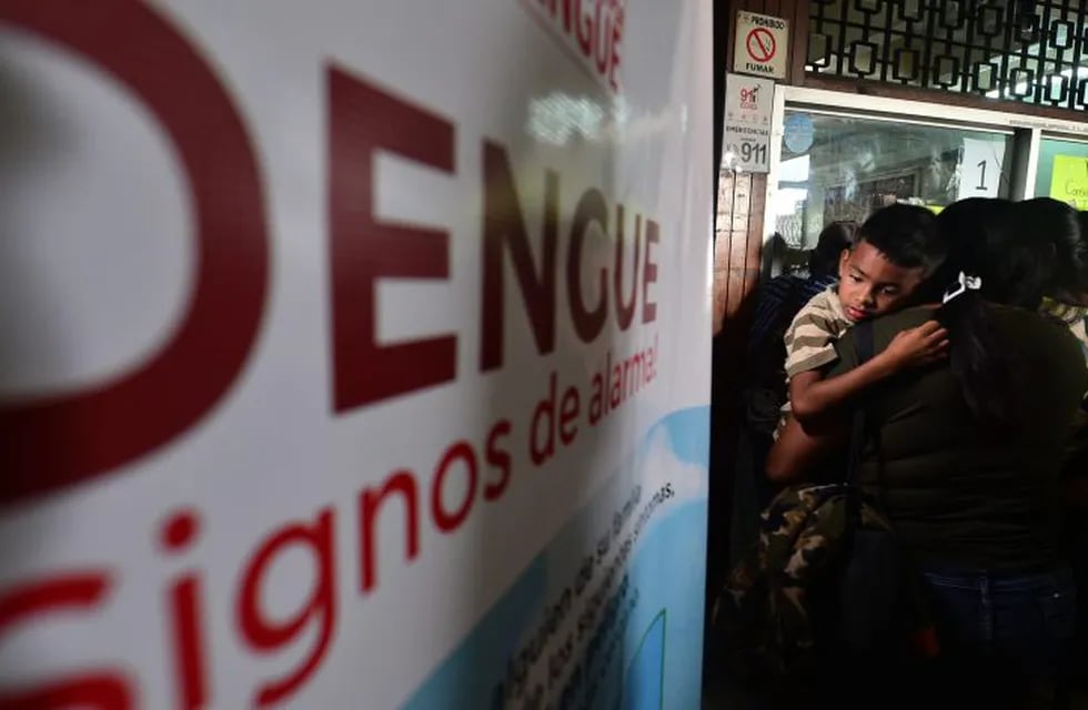 A woman looks for medical attention for her child, allegedly affected by dengue fever, at the Alonso Suazo Health Center in Tegucigalpa on July 22, 2019. - Honduras is under national alert since July 2 for dengue fever, which left at least 54 dead this year according to authorities. (Photo by ORLANDO SIERRA / AFP)