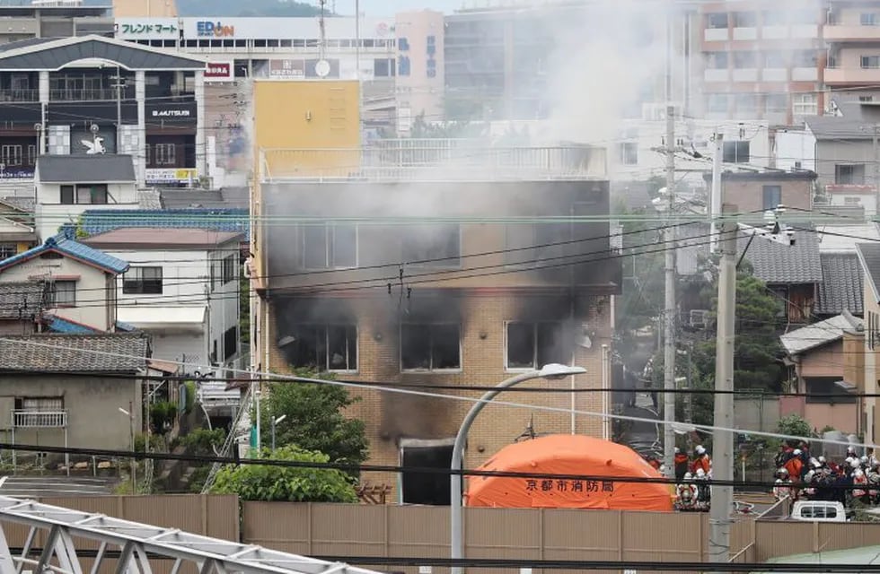 This picture shows a general view of smoke still coming from an animation company building after a fire in Kyoto on July 18, 2019. - At least 24 people are feared dead in a suspected arson attack on the animation company in the Japanese city of Kyoto on July 18, a fire department official told AFP. (Photo by JIJI PRESS / JIJI PRESS / AFP) / Japan OUT