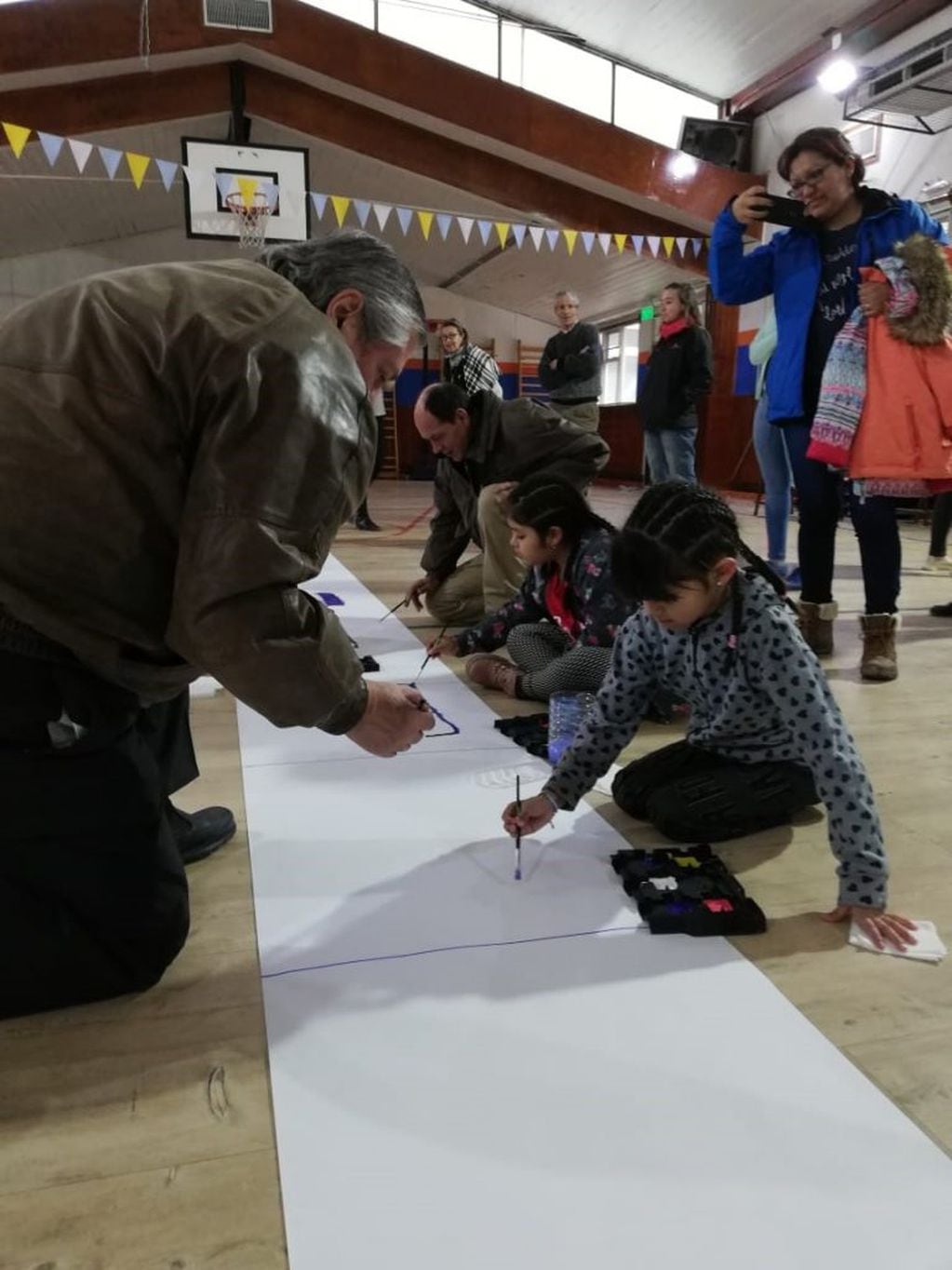 Carlos Latorre, presidente del Centro de Excombatientes de Malvinas en Ushuaia, pintando con los niños