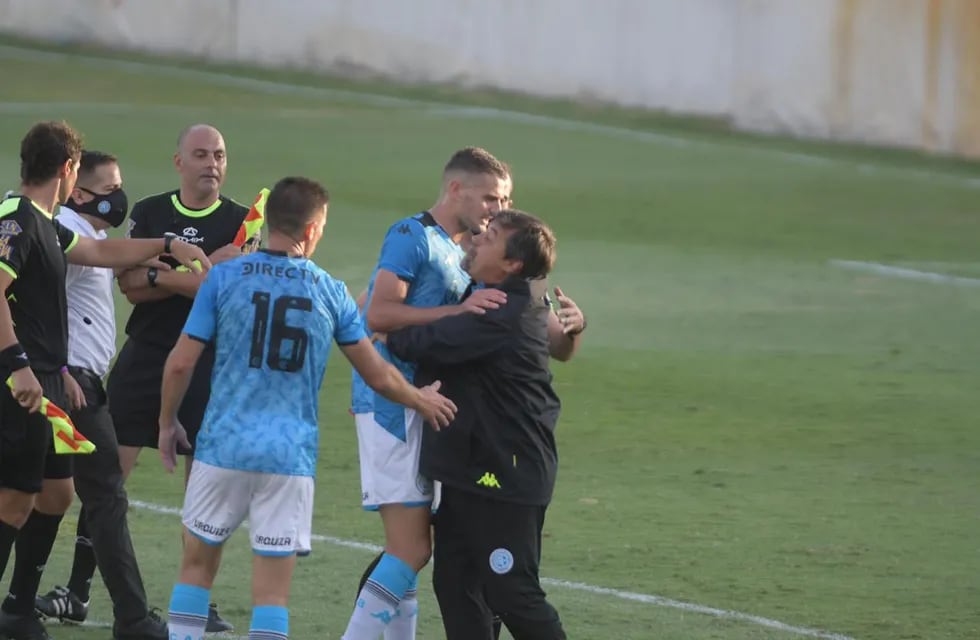El goleador de Belgrano trata de parar a su entrenador que se va con todo a reclamarle al árbitro Nelson Sosa