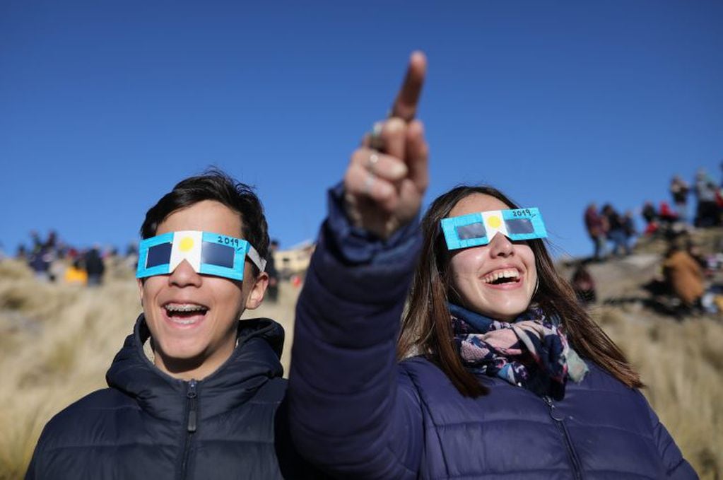 Dos niños con anteojos protectores miran el sol antes del Eclipse solar total este martes, en Merlo, San Luis (Argentina). EFE/Nicolas Aguilera