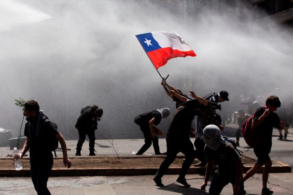 Los manifestantes se enfrentan con la policía antidisturbios durante una protesta en Santiago, Chile, el 21 de octubre de 2019. Crédito: CLAUDIO REYES / AFP.